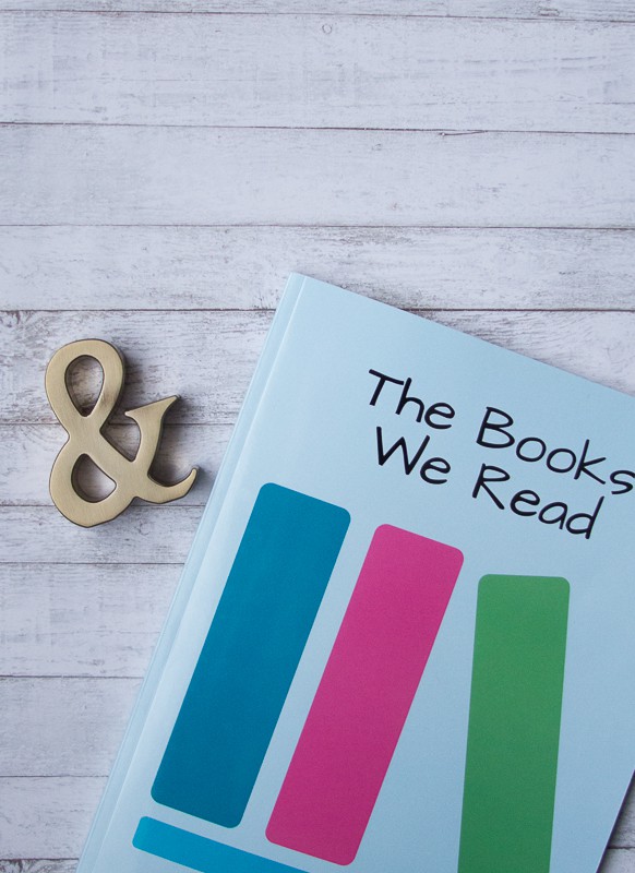 Photo of The Books We Read reading journal, beside an ampersand paperweight